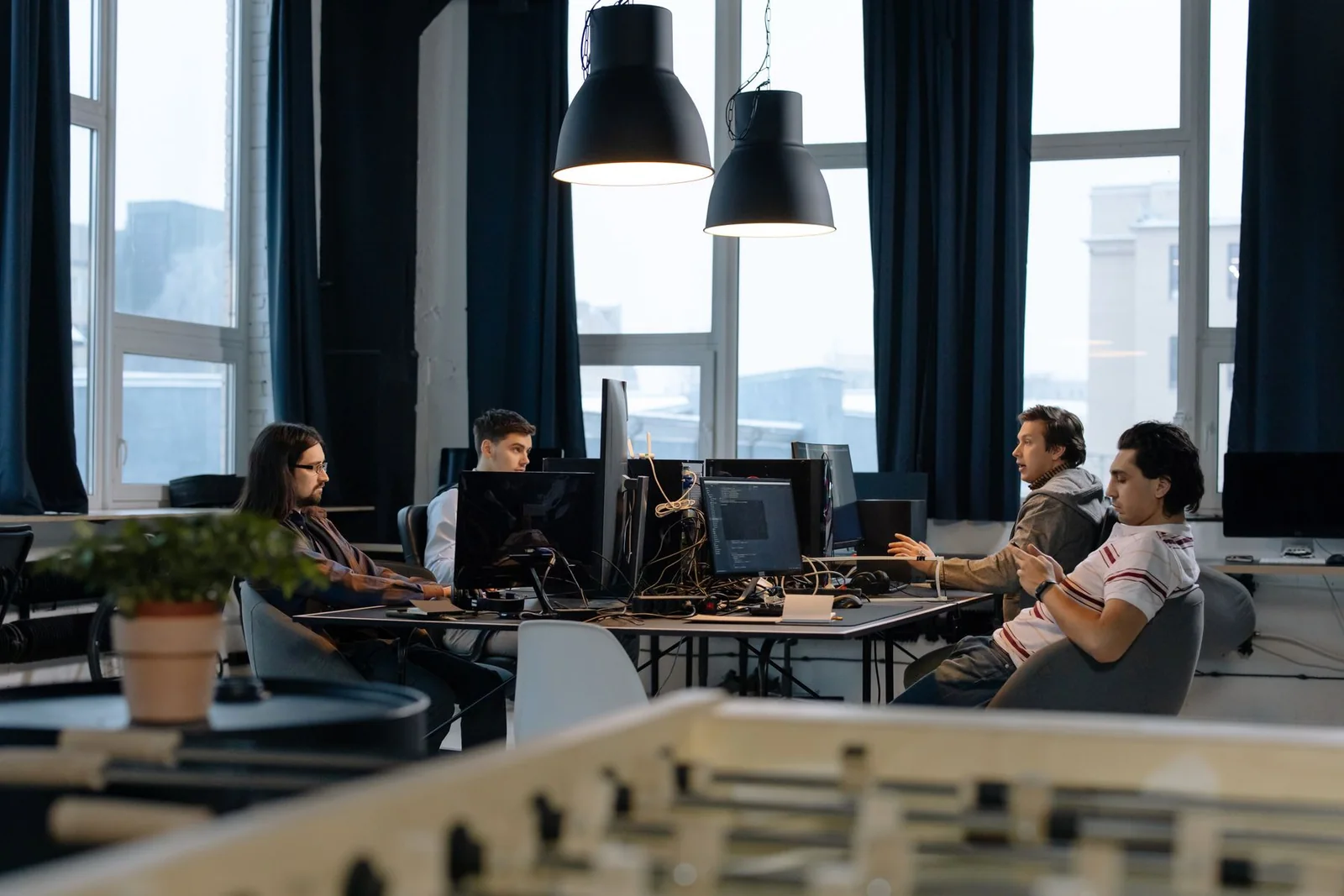 Software team working at shared desks in a daylight studio