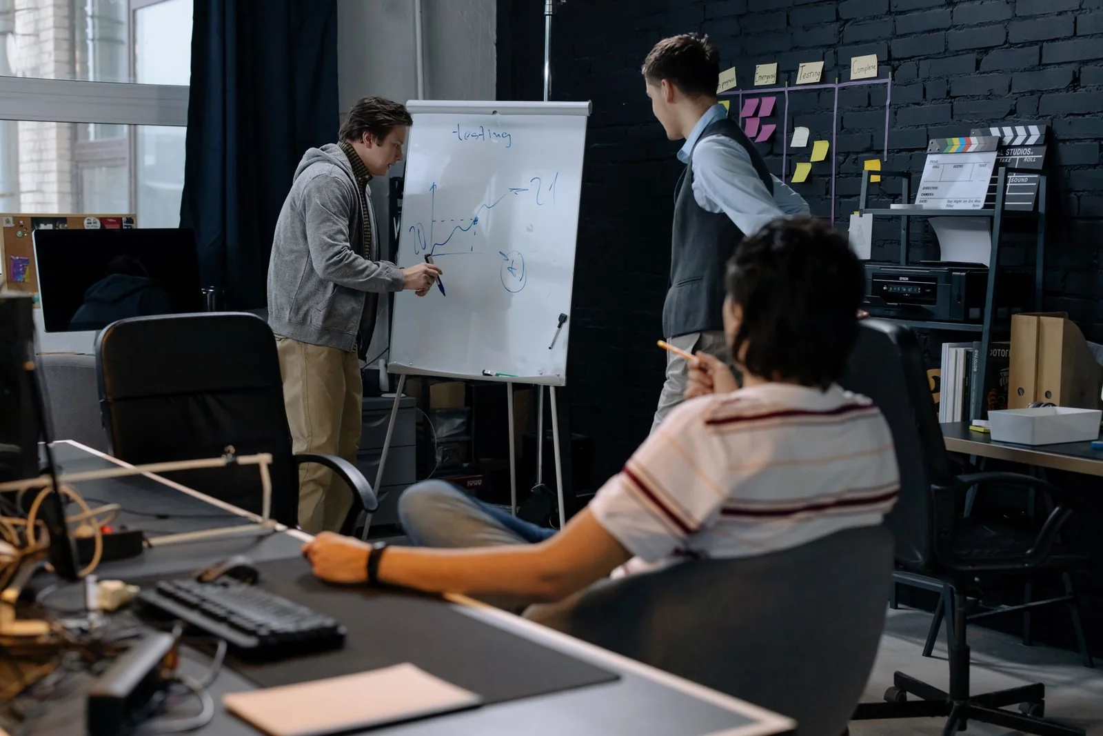 Software team discussing a diagram at a whiteboard